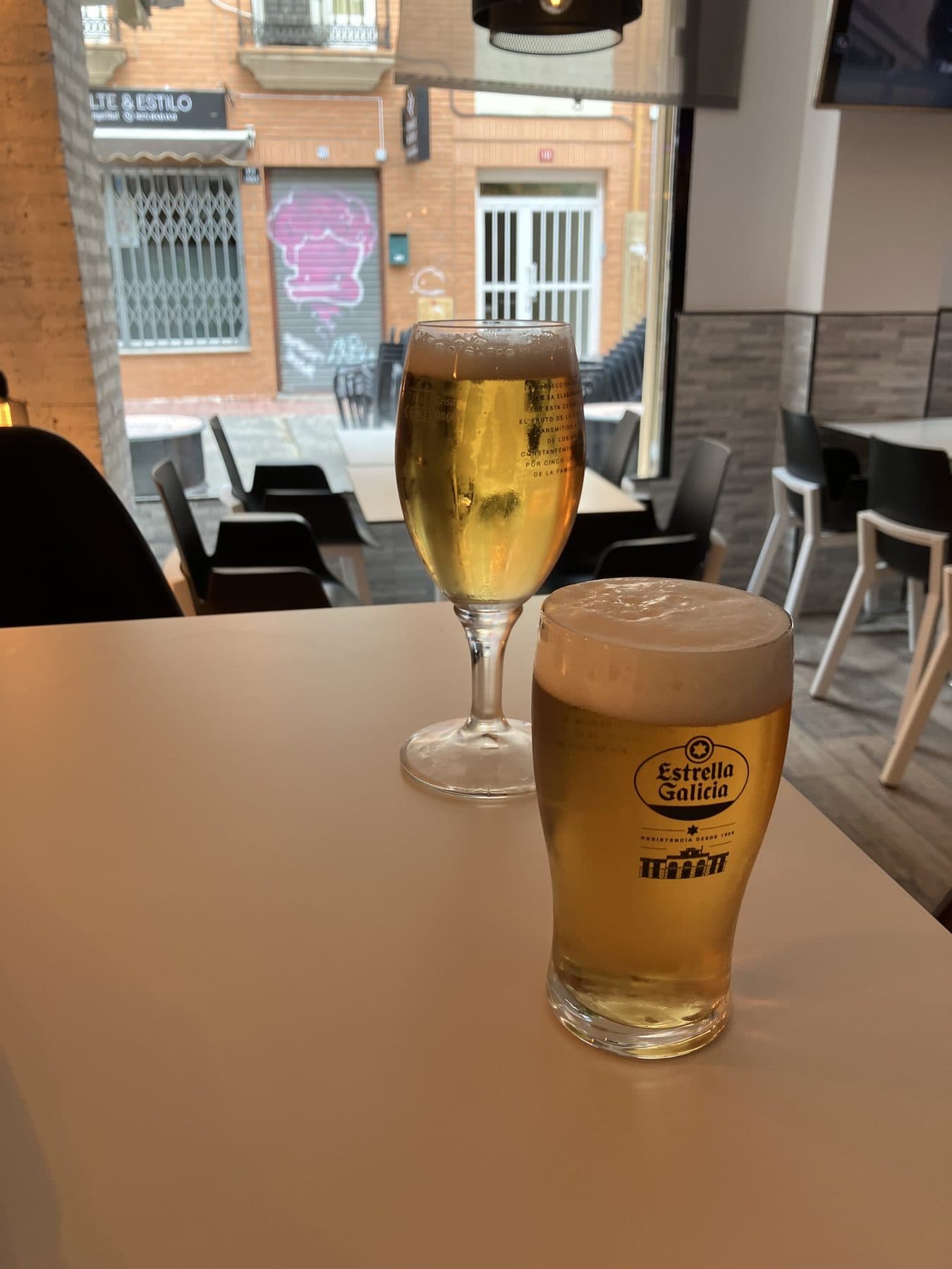 Caña y copa de cerveza en una mesa junto a la terraza