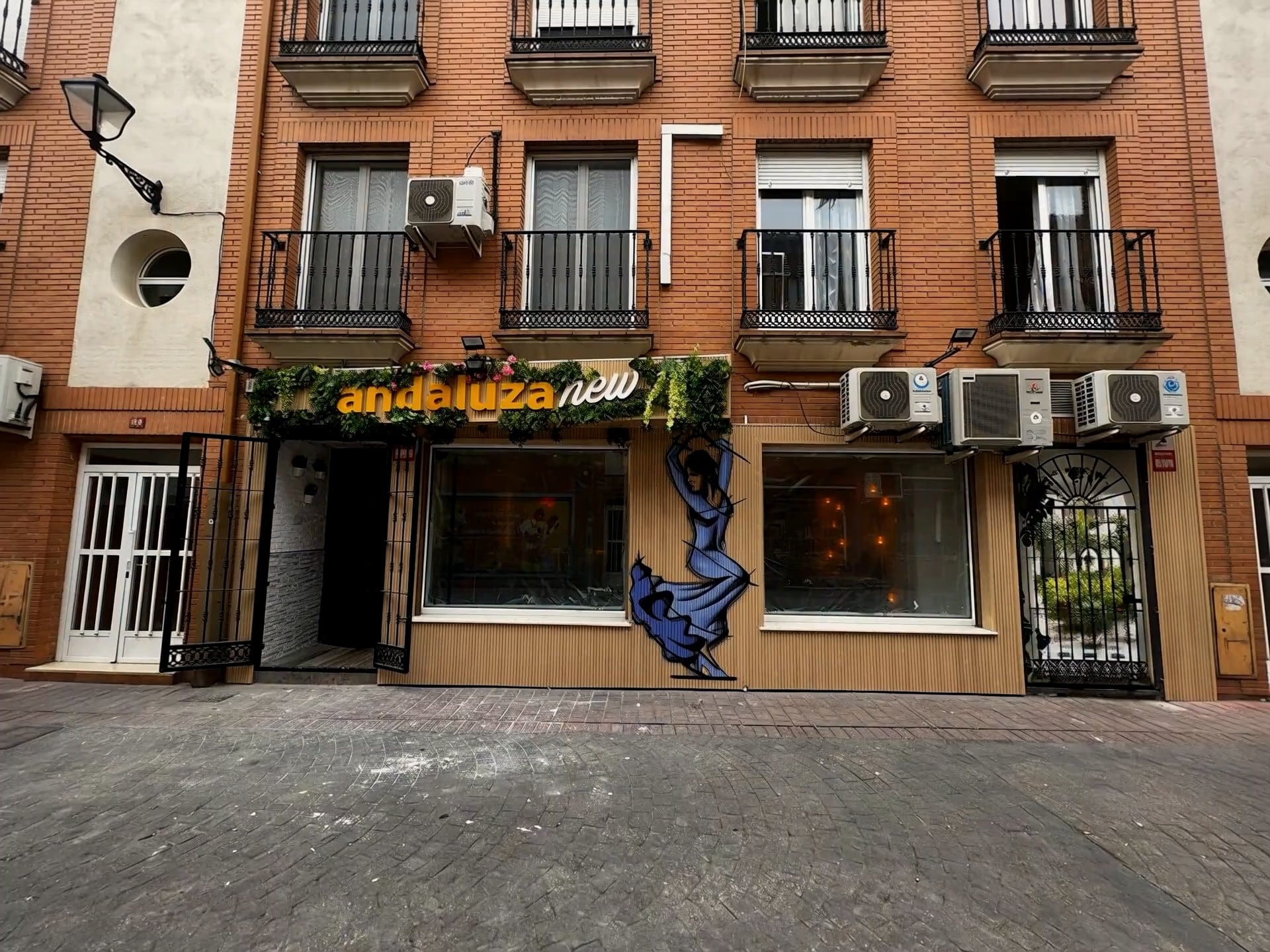 Entrada de La Andaluza New desde la calle, con el rótulo y la flamenca pintada en la fachada