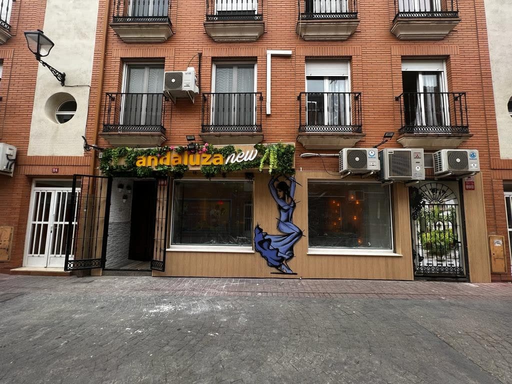 Fachada de La Andaluza New en la calle Sor Livia Alcorta, con el rótulo y el mural de una flamenca