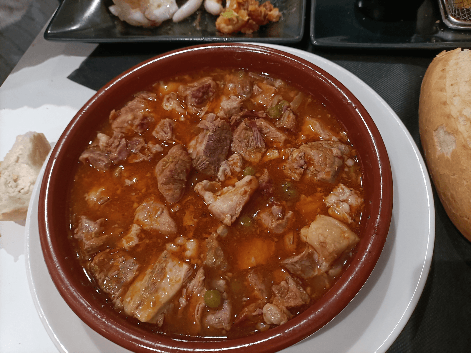Guiso de la casa en cazuela de barro, con pan