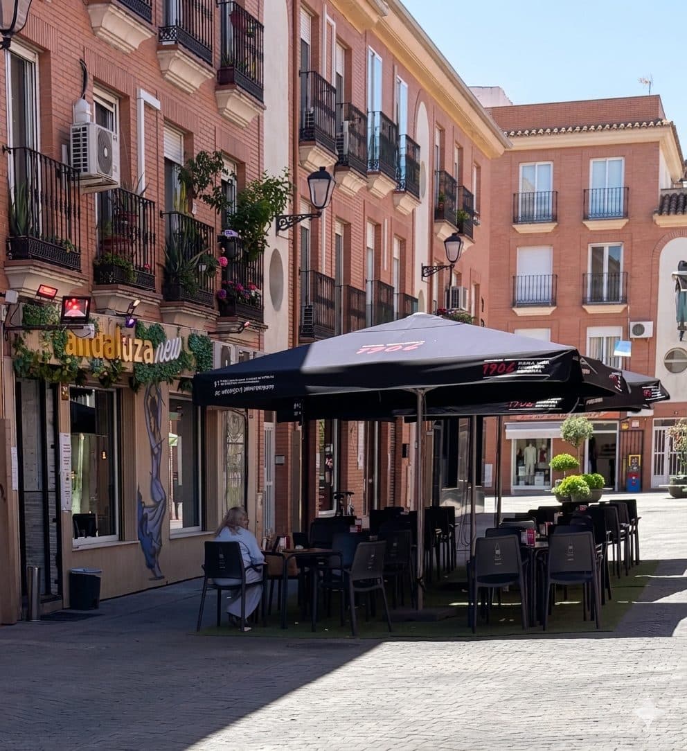 Terraza de La Andaluza New en la calle peatonal Sor Livia Alcorta, con sombrillas negras