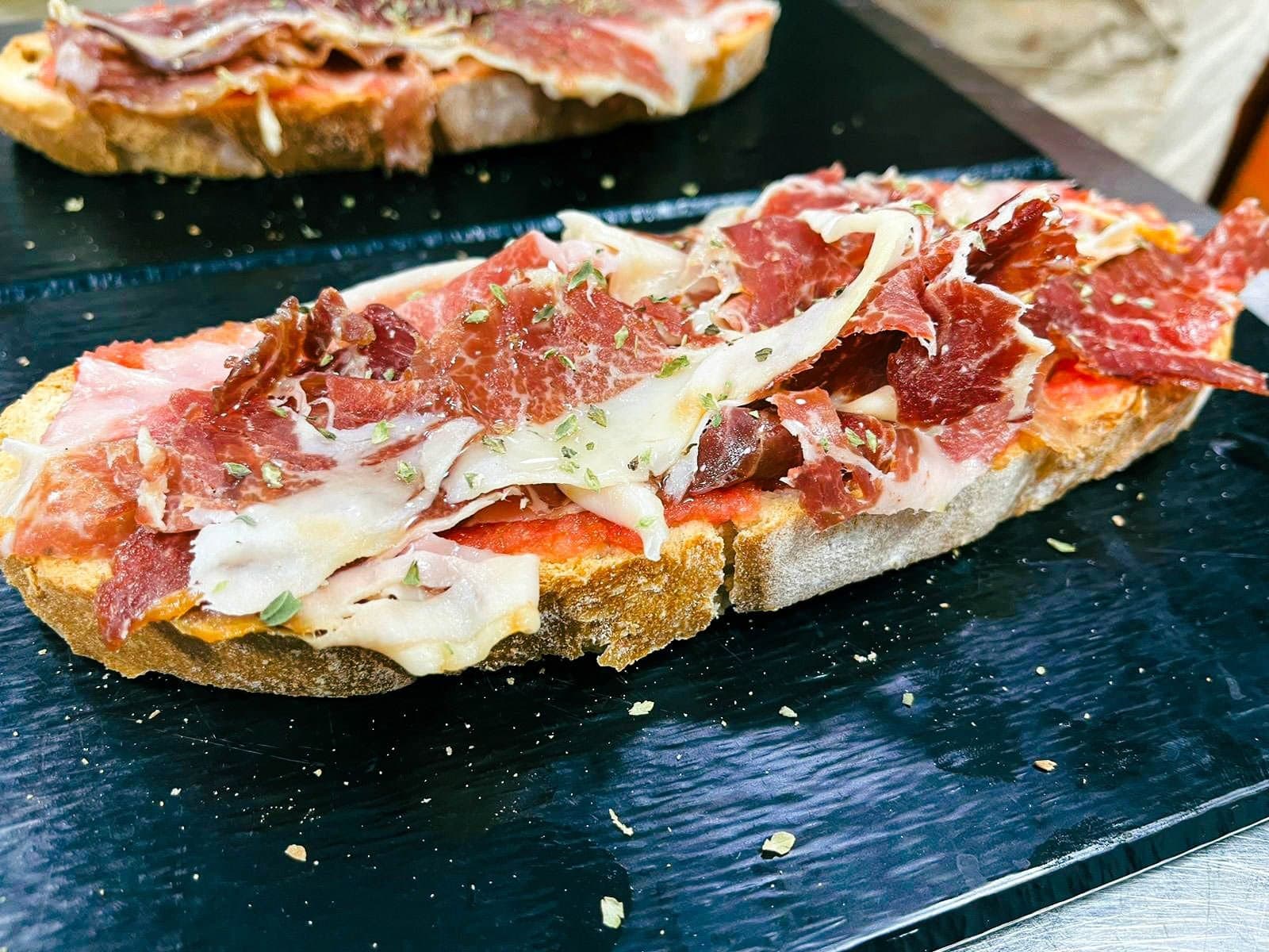 Tosta de jamón ibérico con tomate sobre pizarra