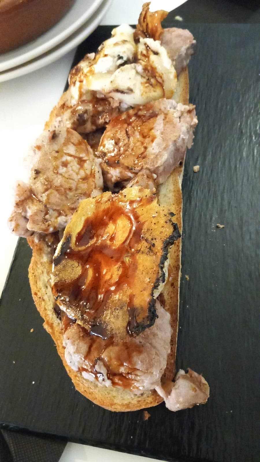 Tosta con cebolla caramelizada sobre pizarra